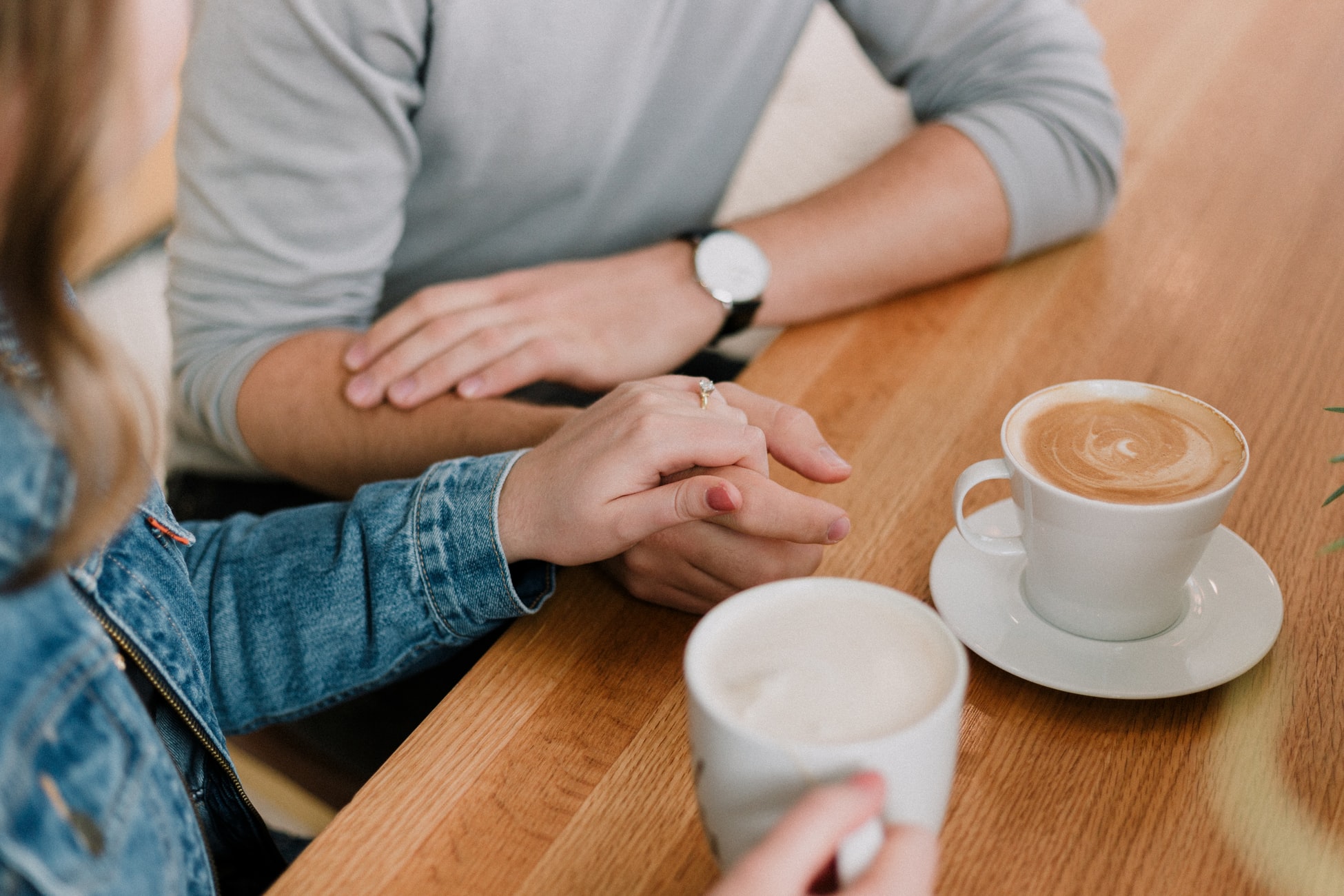 couple holding hands with coffee